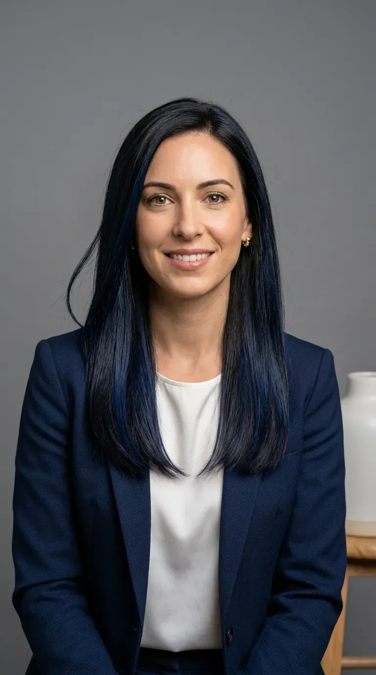 Woman with dark brunette hair and rich navy blue balayage highlights styled sleek