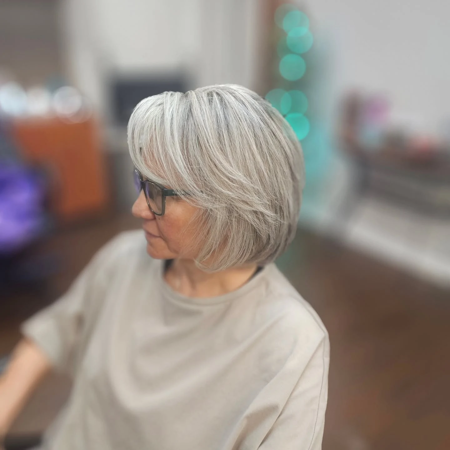 Woman over 60 with bob hairstyle styled with a dramatic deep side part