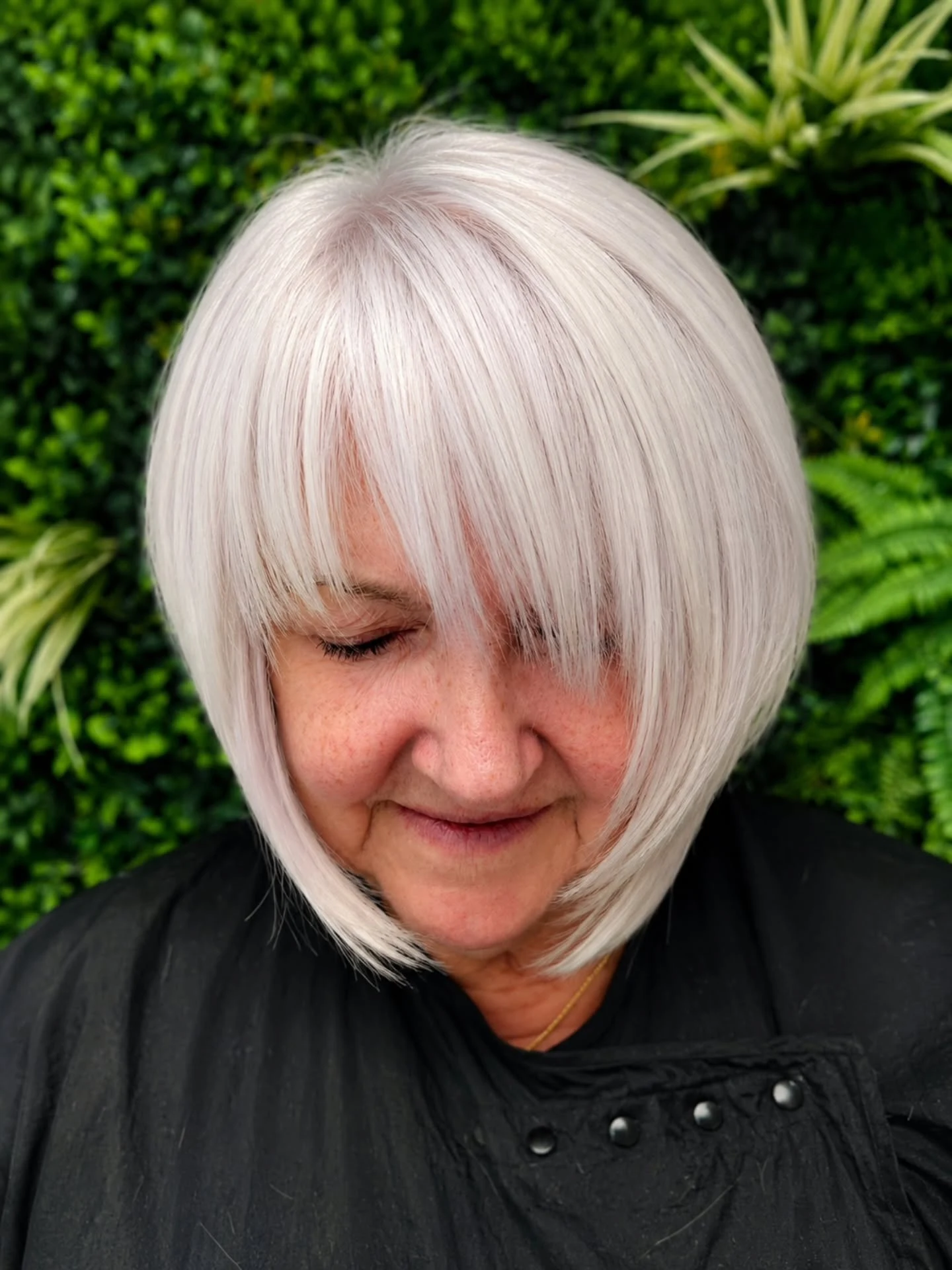 Woman over 60 with square face shape wearing a bob softened around the jaw