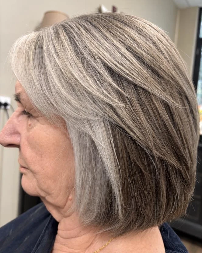 Woman over 60 with subtle face-framing highlights on a bob hairstyle
