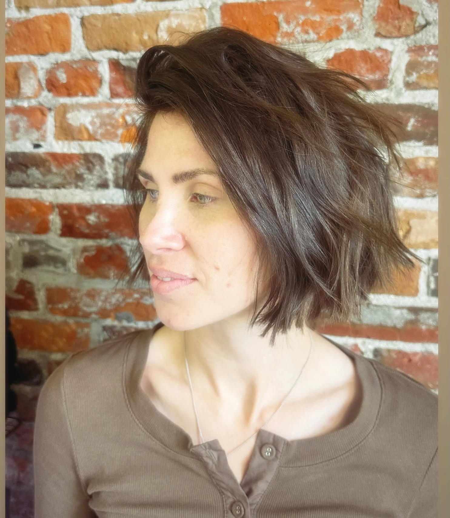 Woman with thin fine hair wearing a choppy shag bob styled with lifted root volume