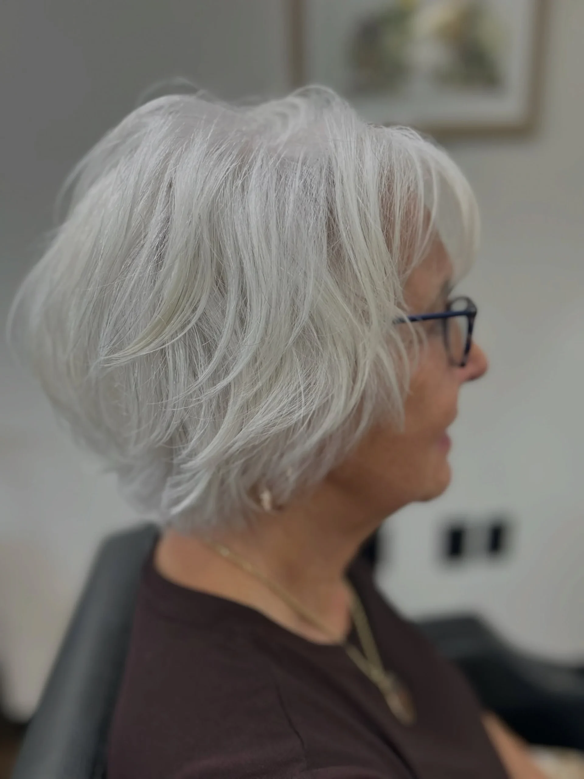 Woman over 60 with classic chin-length bob featuring soft face-framing pieces