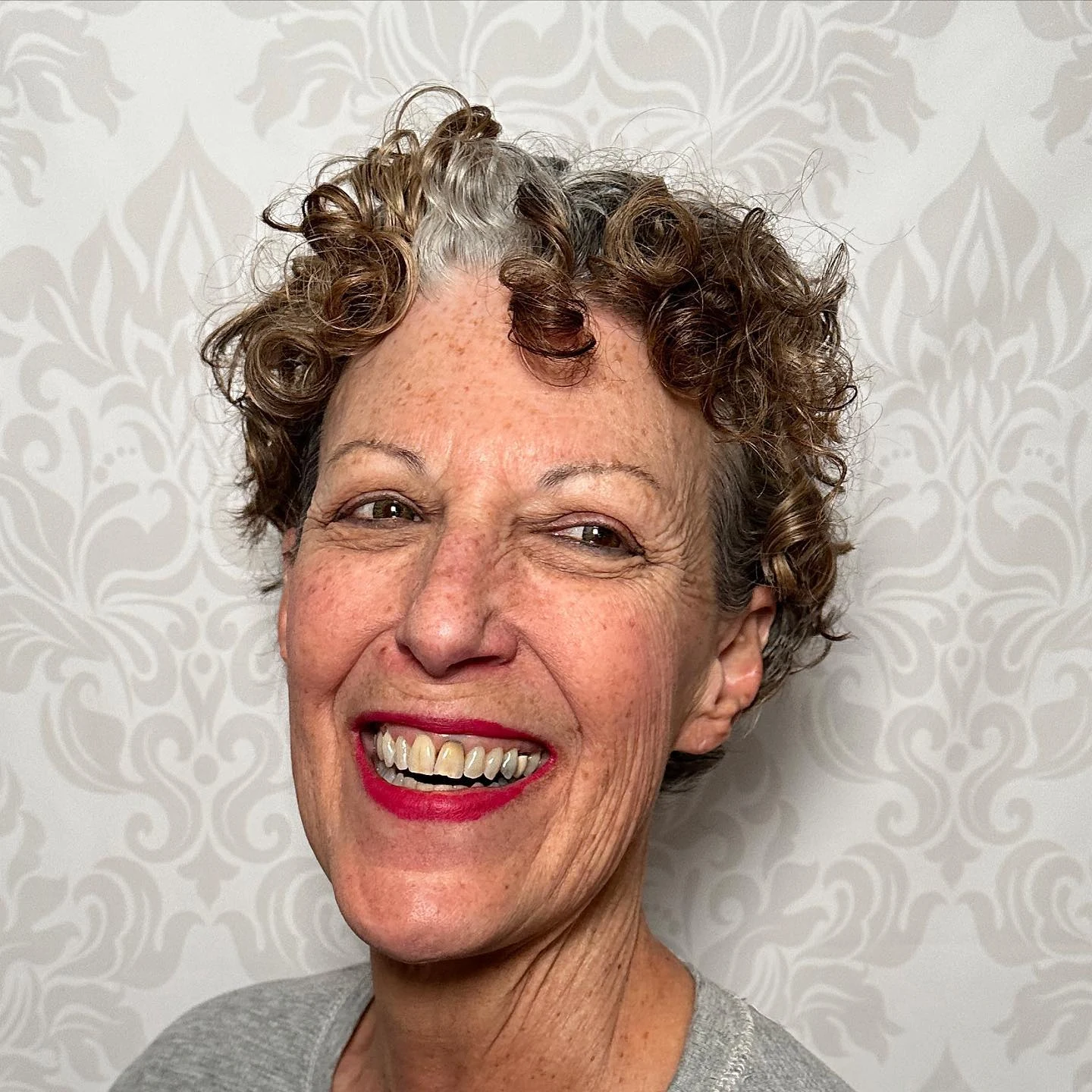 Woman over 60 with natural curly hair cut into a bob with defined bouncy curls