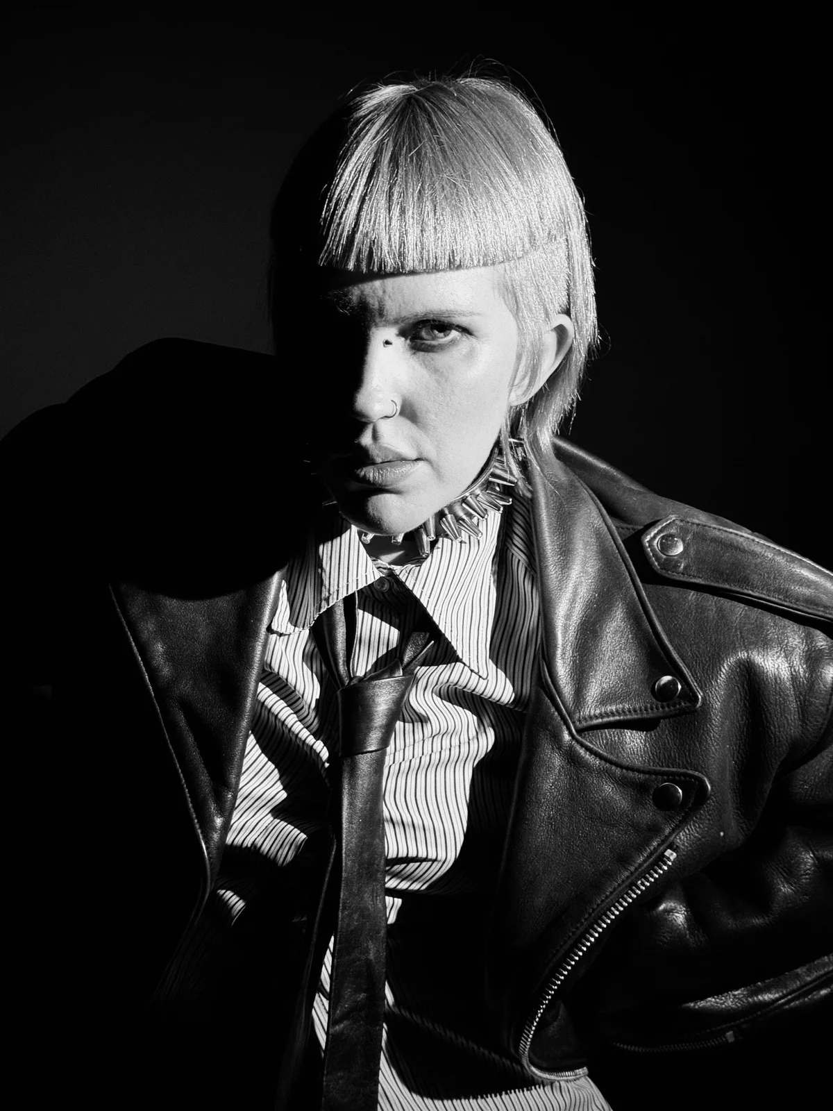 Woman with an edgy editorial-style pixie featuring sharp, blunt-cut edges