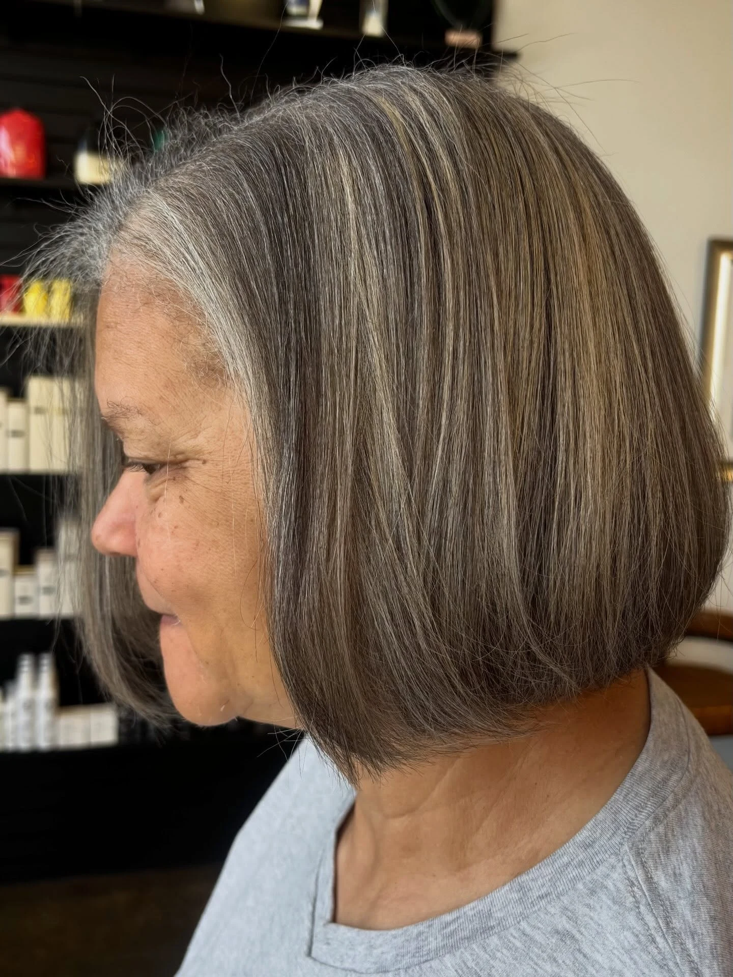 Woman over 60 with gray-blending balayage highlights on a bob hairstyle