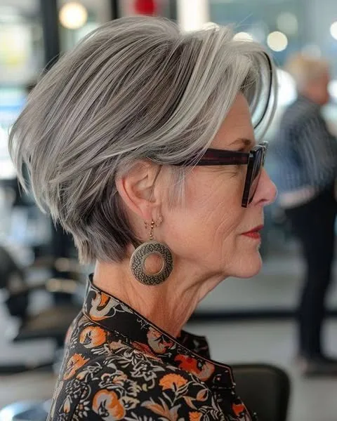 Woman over 50 with a chic short layered grey bob swept to the side