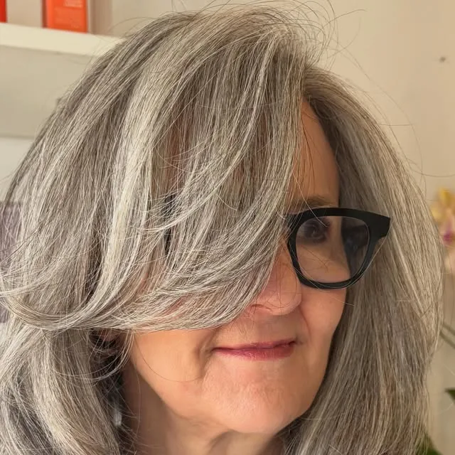 Woman over 50 with fine hair wearing a long layered cut with face-framing pieces