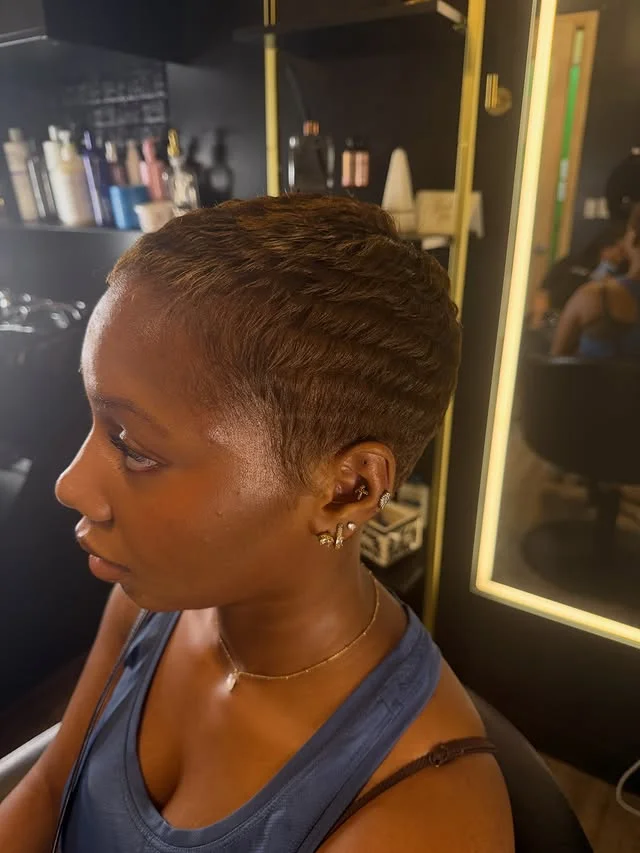 Woman with an edgy micro pixie haircut cropped extremely close to the scalp