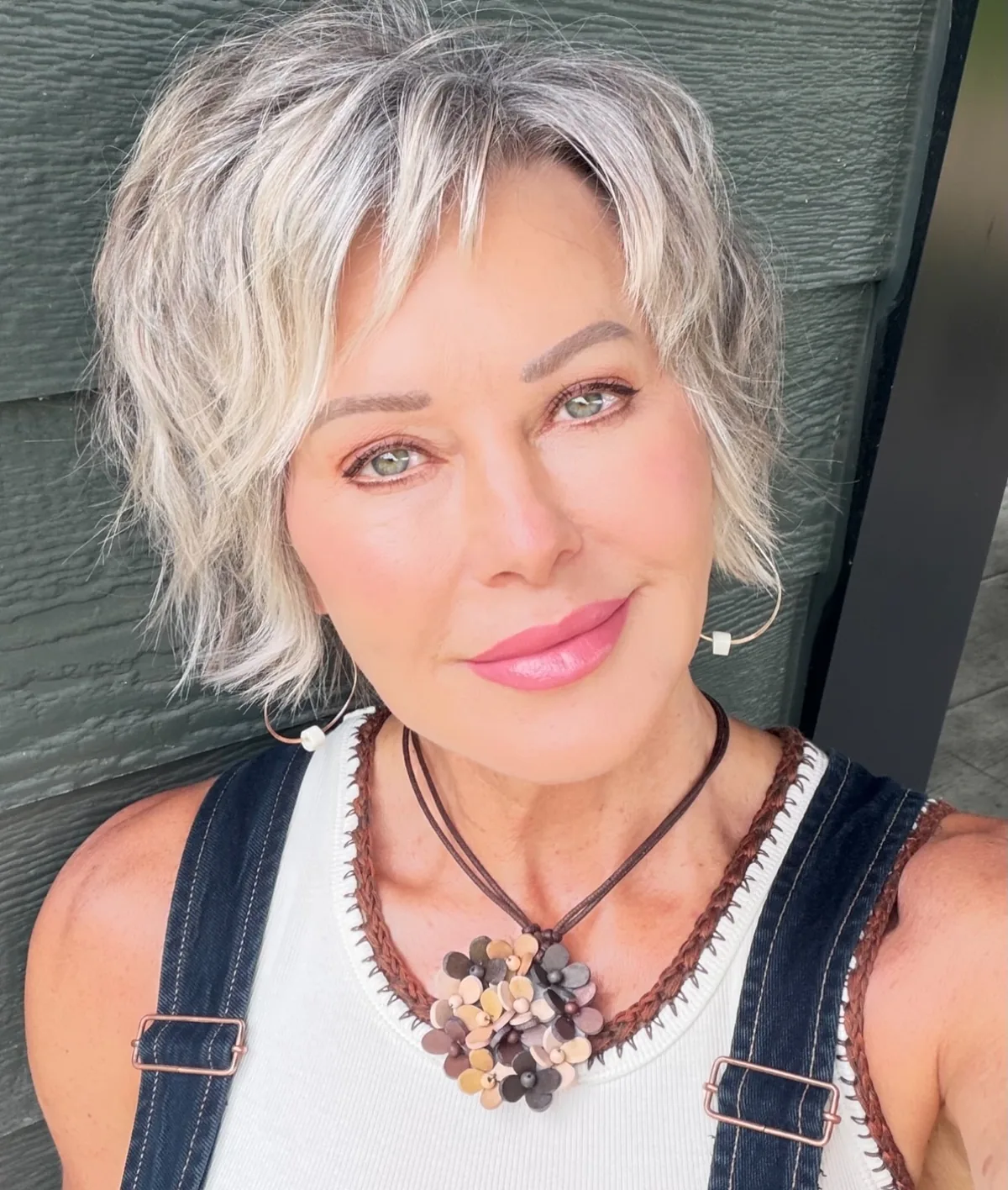 Woman over 60 with gray-blonde hair wearing a textured pixie-bob hybrid
