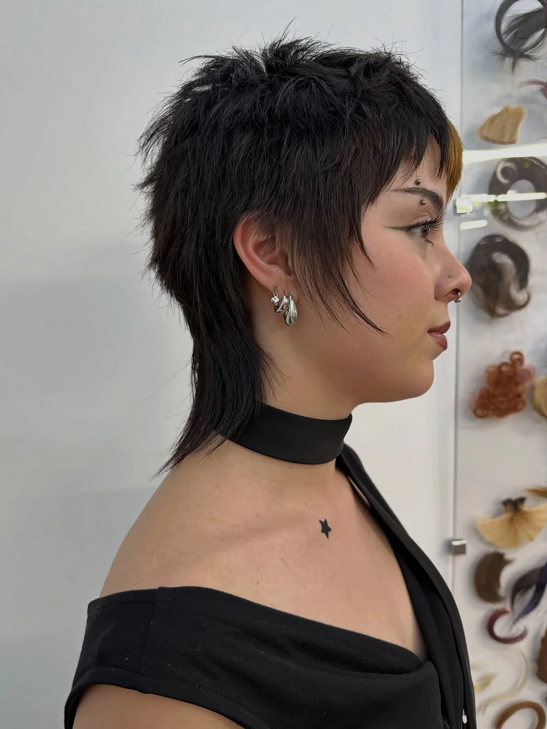 Woman with an edgy pixie mullet featuring short sides and a longer textured back