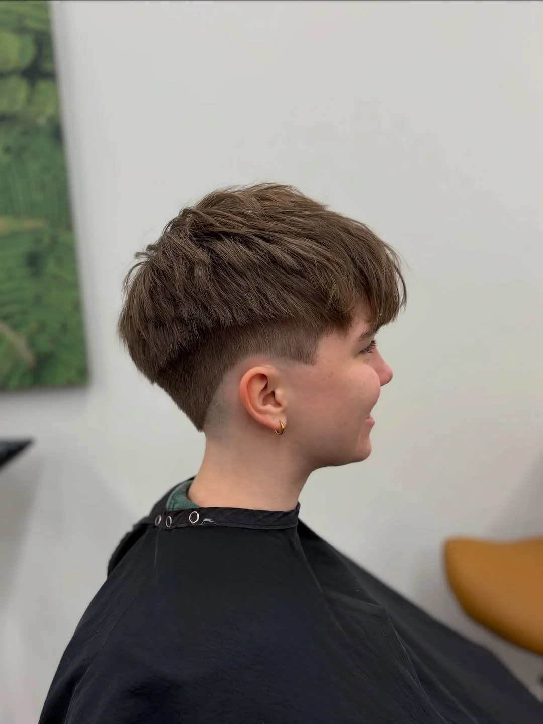 Woman with an edgy pixie featuring a piece-y textured crown and a clean, precise undercut