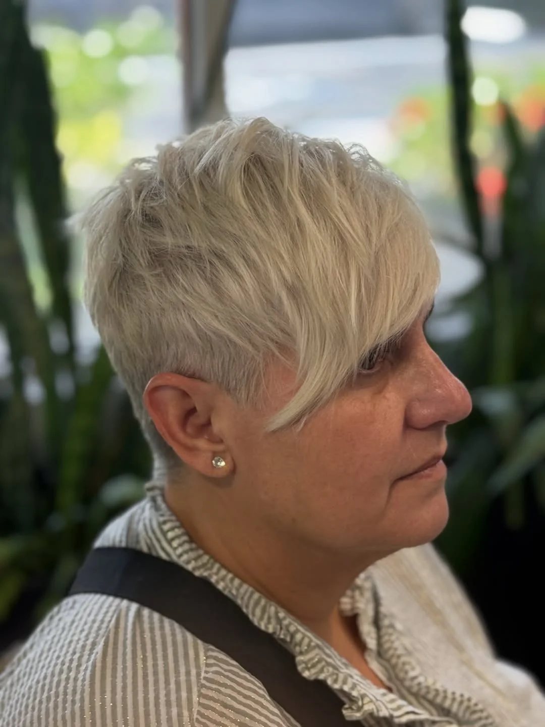 Woman with an edgy pixie featuring a side-shaved undercut and a long, sweeping top