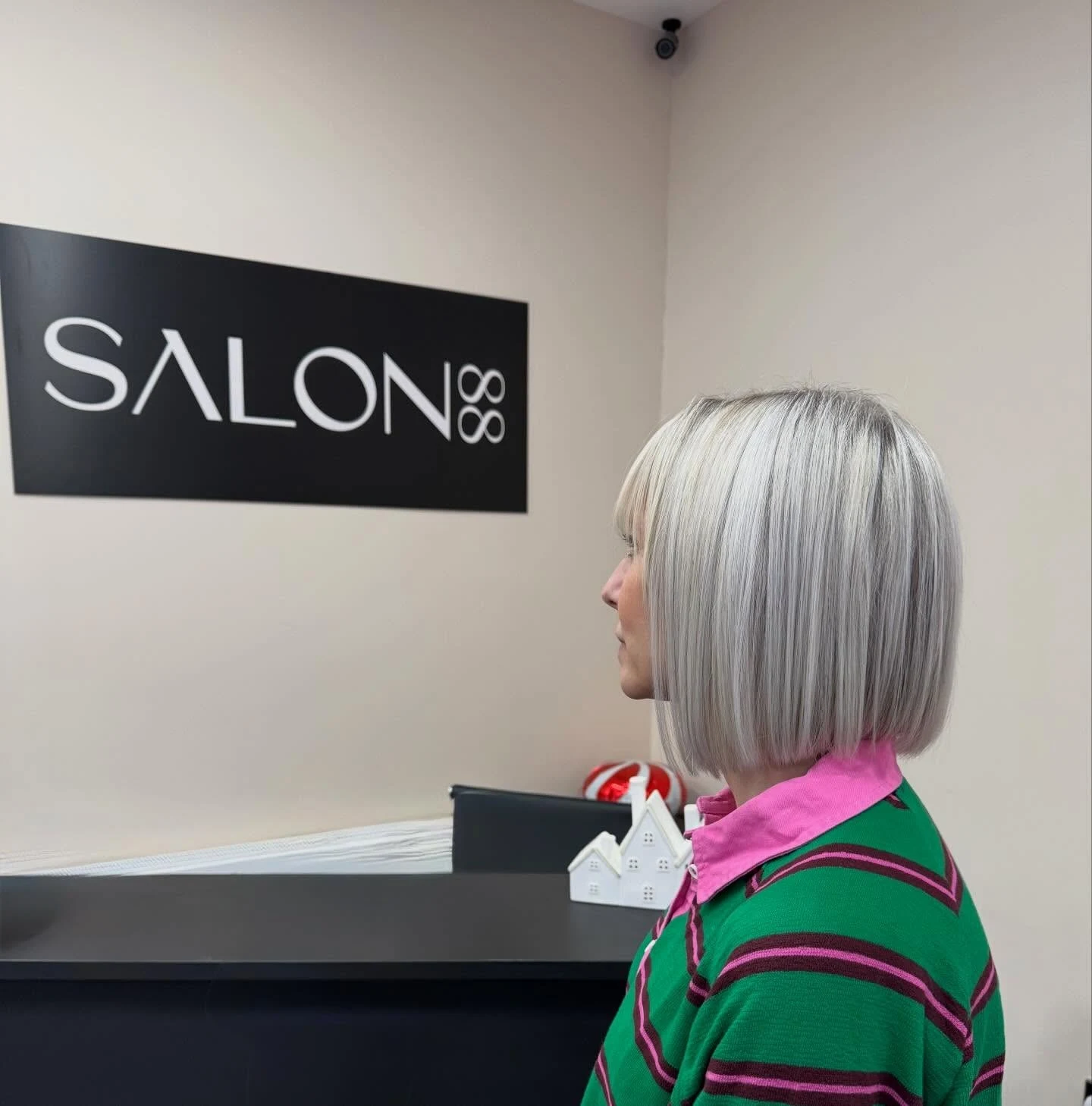 Woman over 60 applying purple-toning product to brighten a silver bob