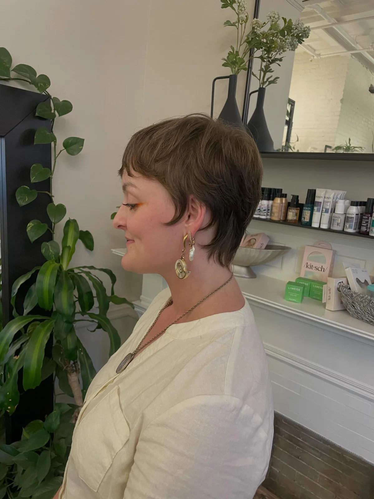Woman with an edgy razored pixie featuring fine, piece-y textured ends