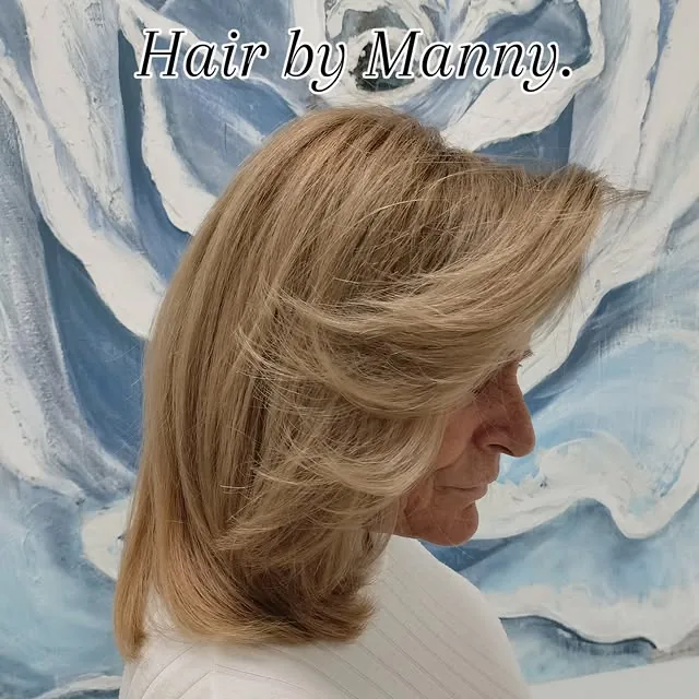 Woman over 50 with a side-parted layered bob with visible root lift