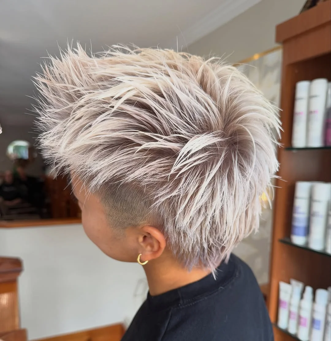 Woman with an edgy silver-toned textured pixie haircut with piece-y layers