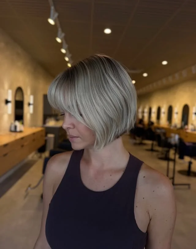 Sleek Short Bob with Long Side-Swept Bangs for Round Faces