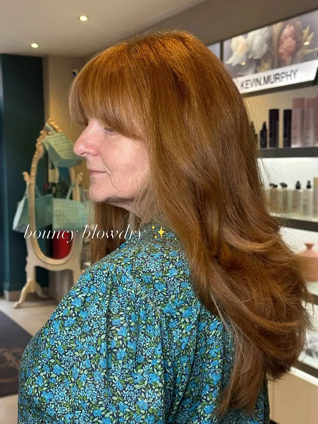 Woman over 50 with a soft, bouncy blowout of long waves