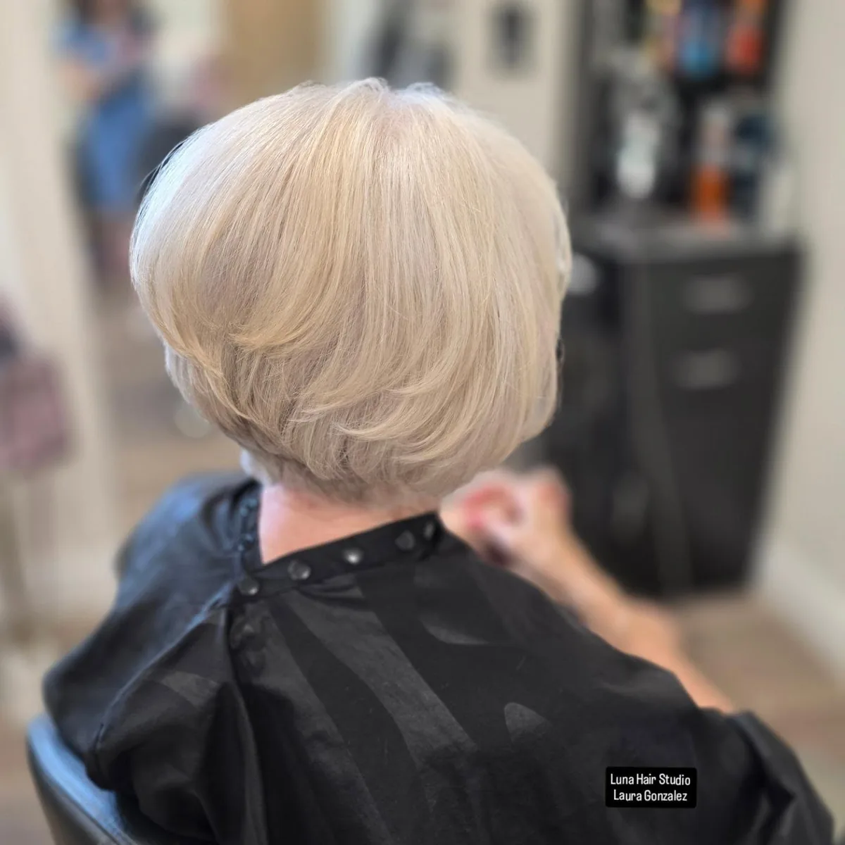 Woman over 60 with fine blonde hair wearing a stacked bob for fullness