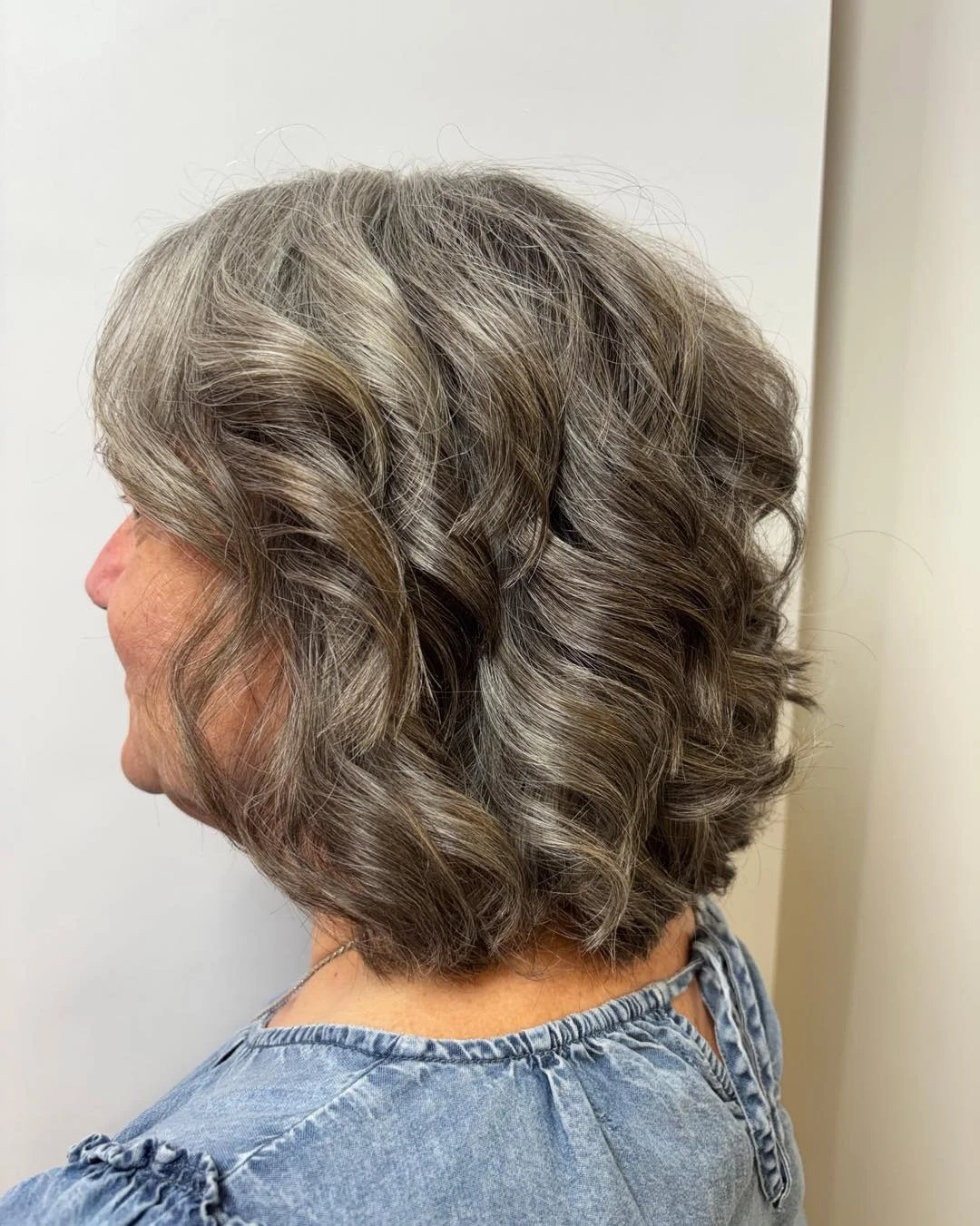 Woman over 60 with naturally wavy hair cut into a wavy bob