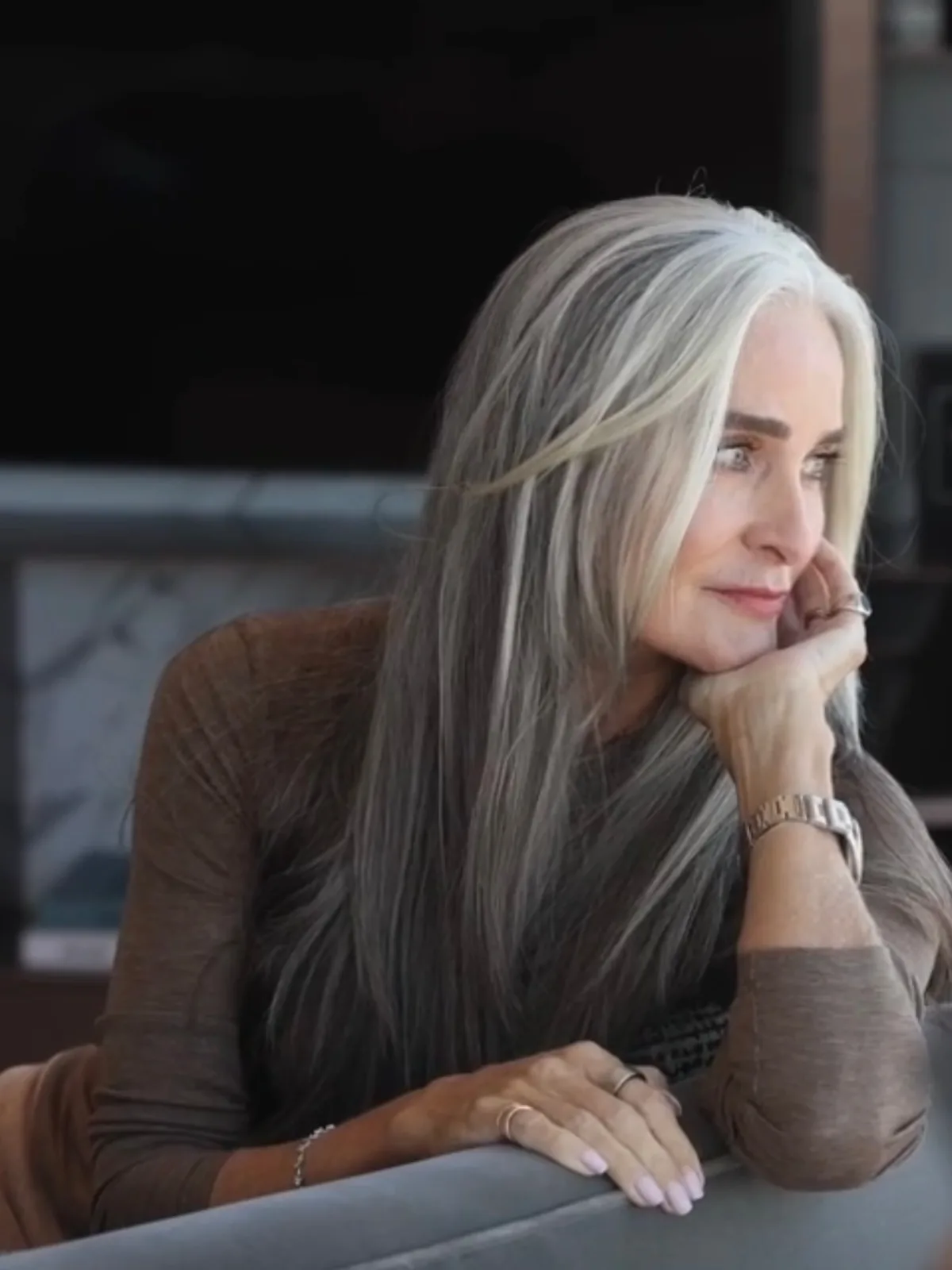 Woman over 50 with long layered hair and light wispy bangs