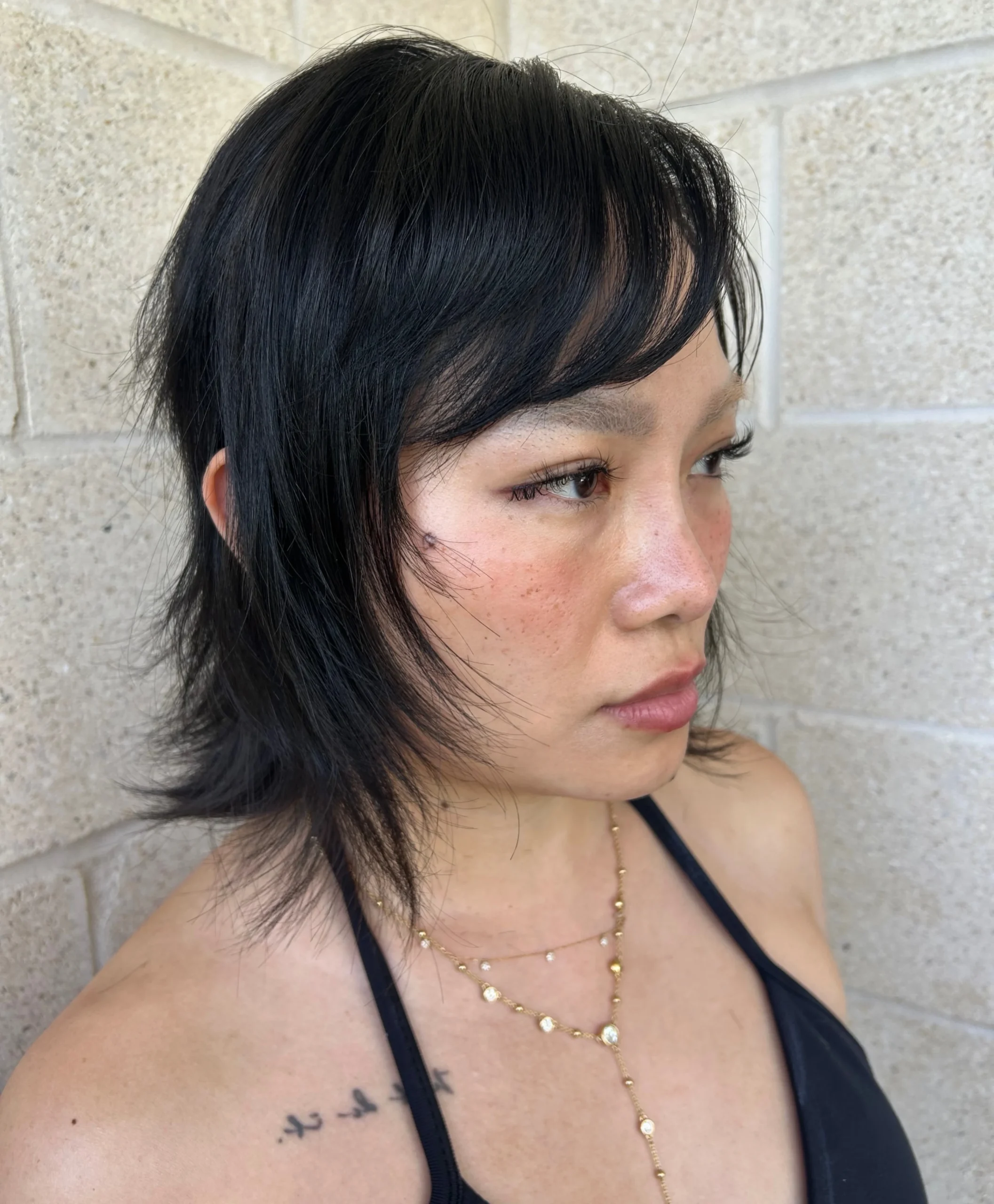 Woman with thin fine hair wearing a wispy shag bob with light, airy texture