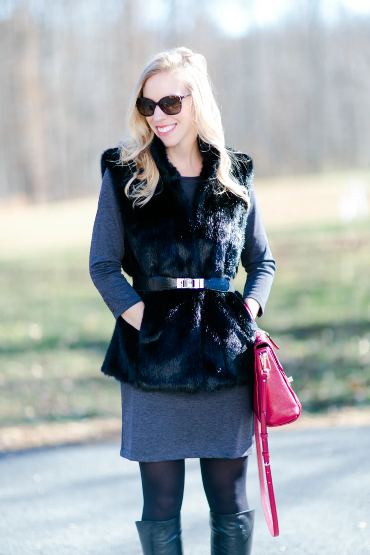 Woman in charcoal swing dress and faux-fur vest in a winter setting