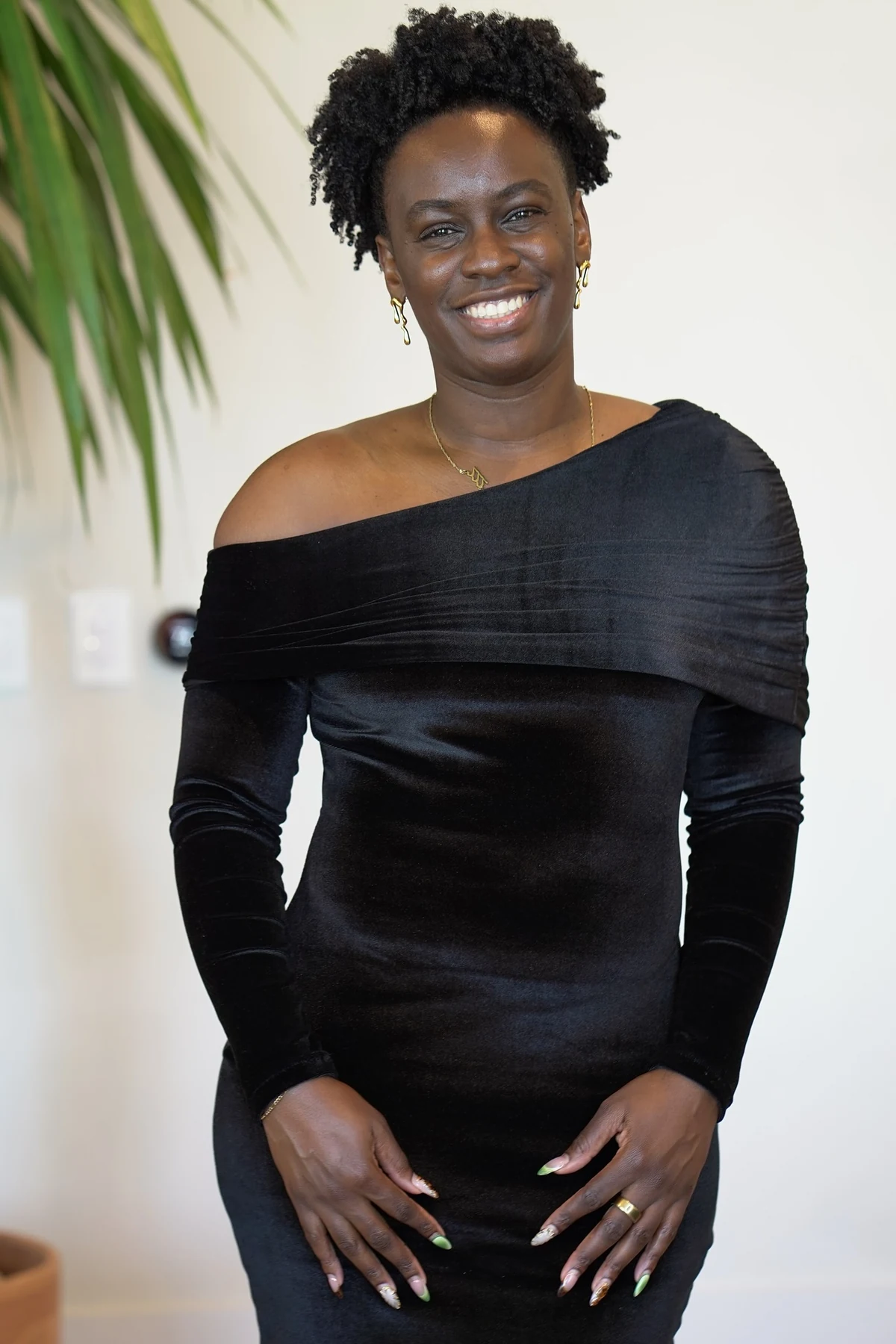 Woman in black velvet off-the-shoulder dress indoors