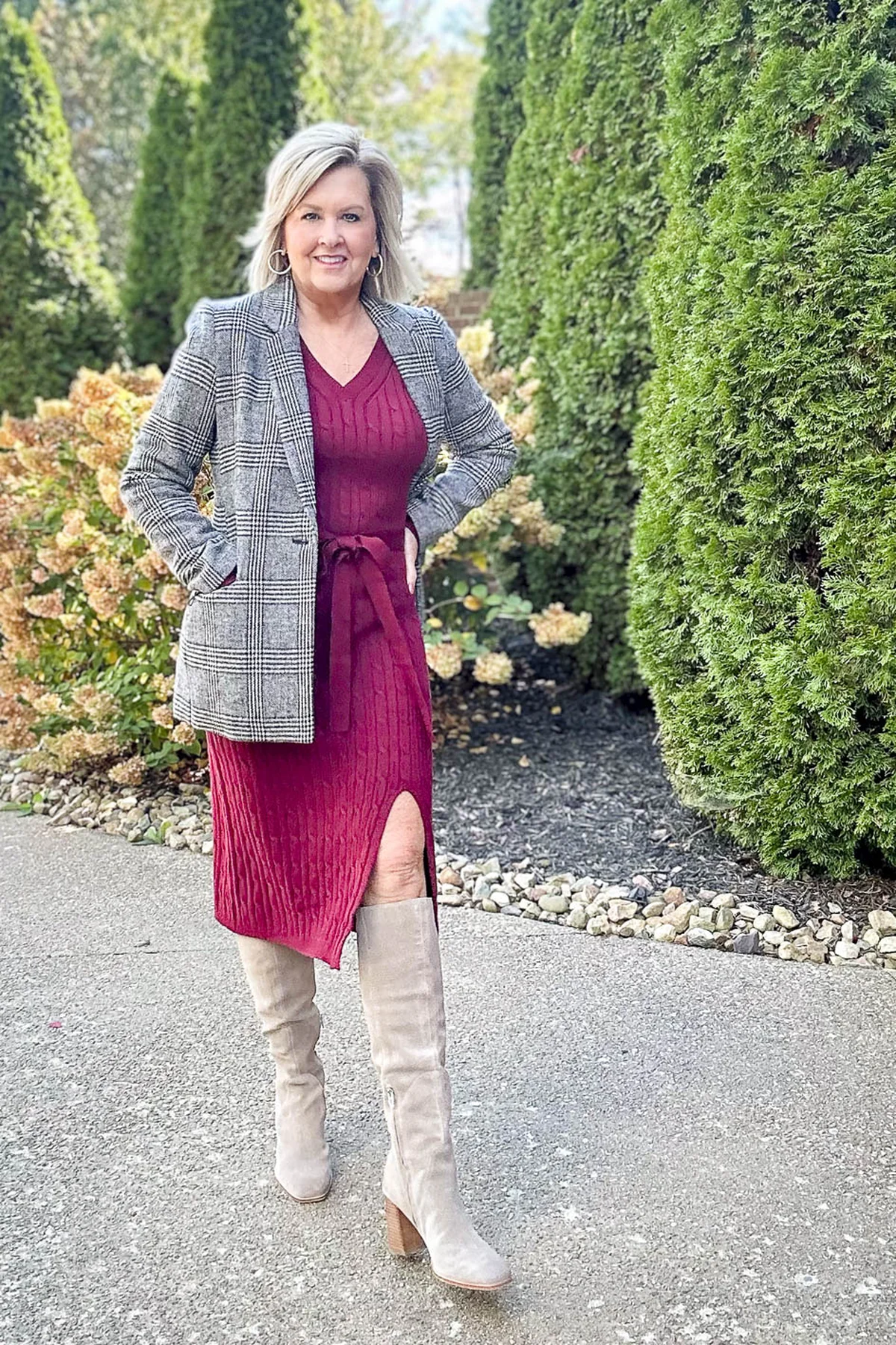 Woman in a red cable-knit sweater dress with tie waist and taupe knee boots