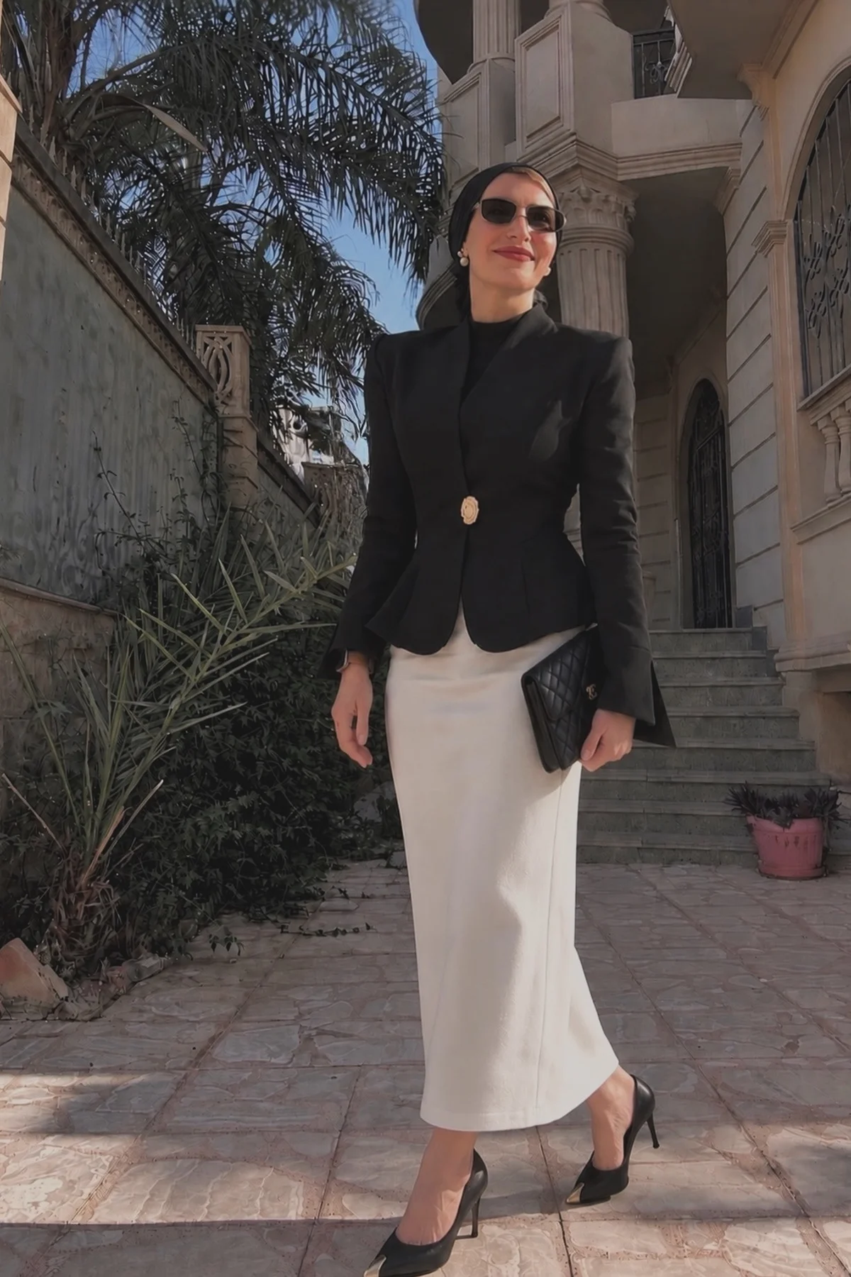 Woman in black blazer, plum satin maxi skirt and hijab, a chic Christmas outfit for dinner