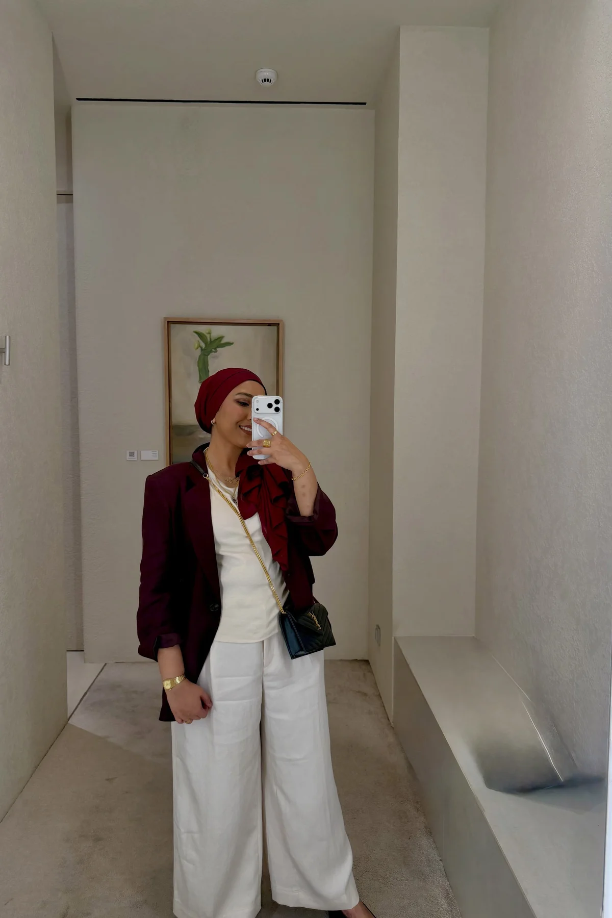 Hijabi woman in burgundy velvet blazer and black satin trousers heading to a Christmas dinner