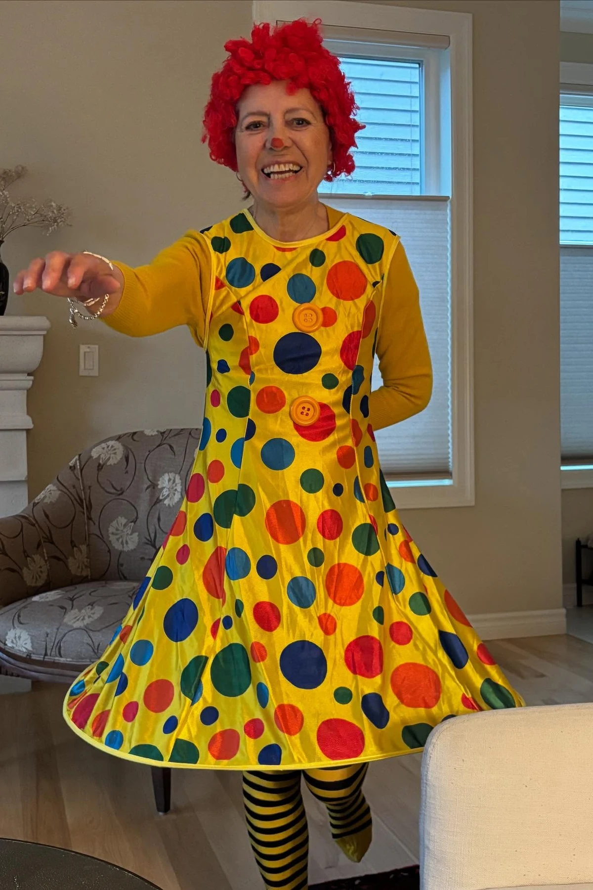 Woman over 50 in a bright thrifted blouse with creepy clown face paint, a DIY creepy clown Halloween costume