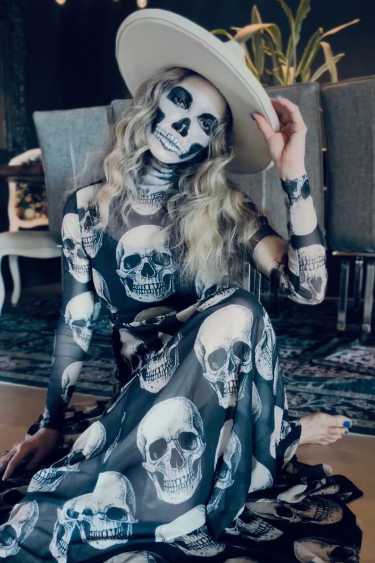 Woman over 50 in all black with skeleton face paint, a DIY skeleton Halloween costume