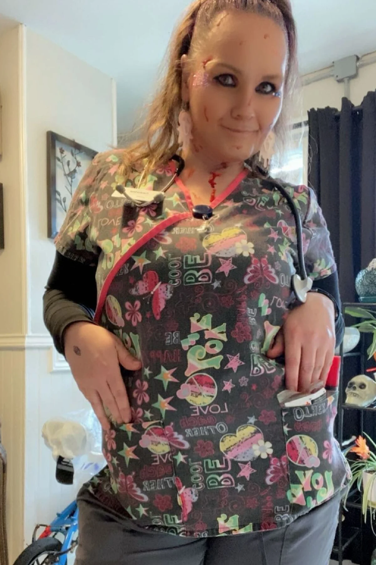 Woman over 50 in white scrubs with a red cross and creepy nurse makeup, a DIY creepy nurse Halloween costume