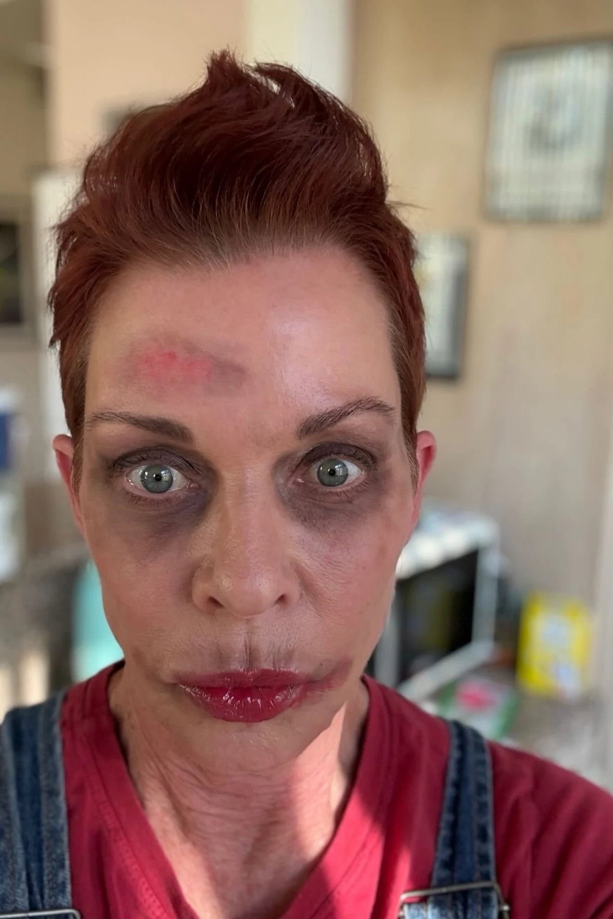 Woman over 50 in an apron and curlers with zombie makeup, a DIY zombie housewife Halloween costume