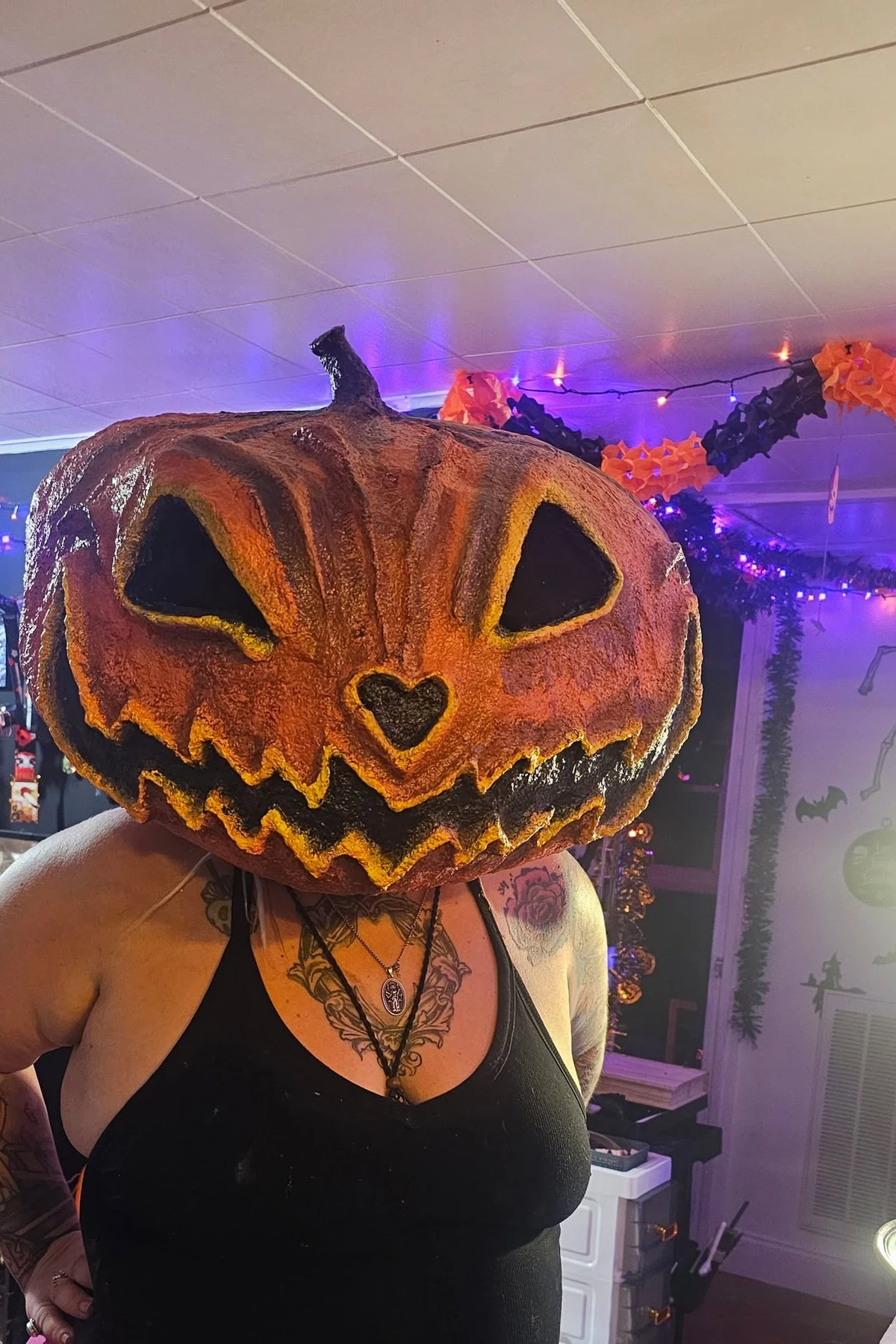Woman wearing a handmade papier-mache pumpkin head mask, a DIY pumpkin head Halloween costume