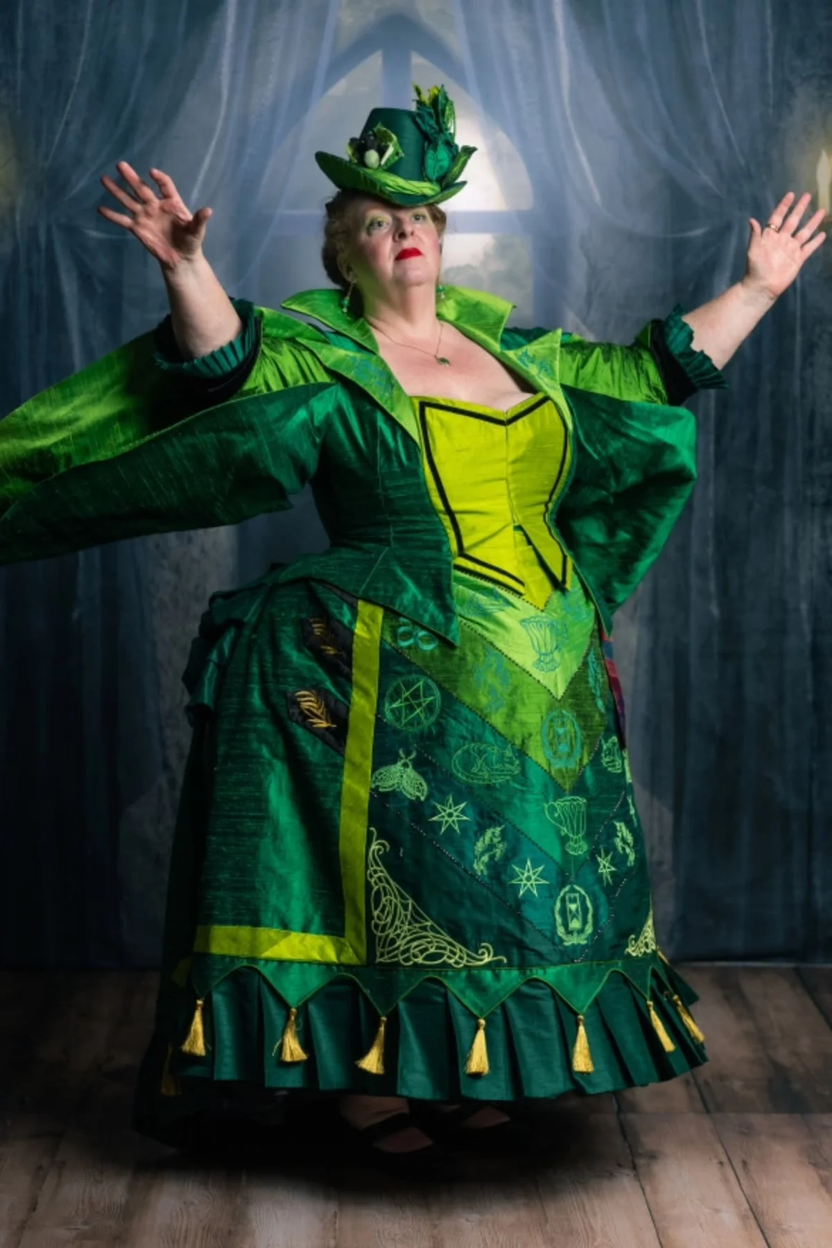 Woman in her 50s in layered torn green shawls with moss and twigs, a swamp creature solo horror Halloween costume