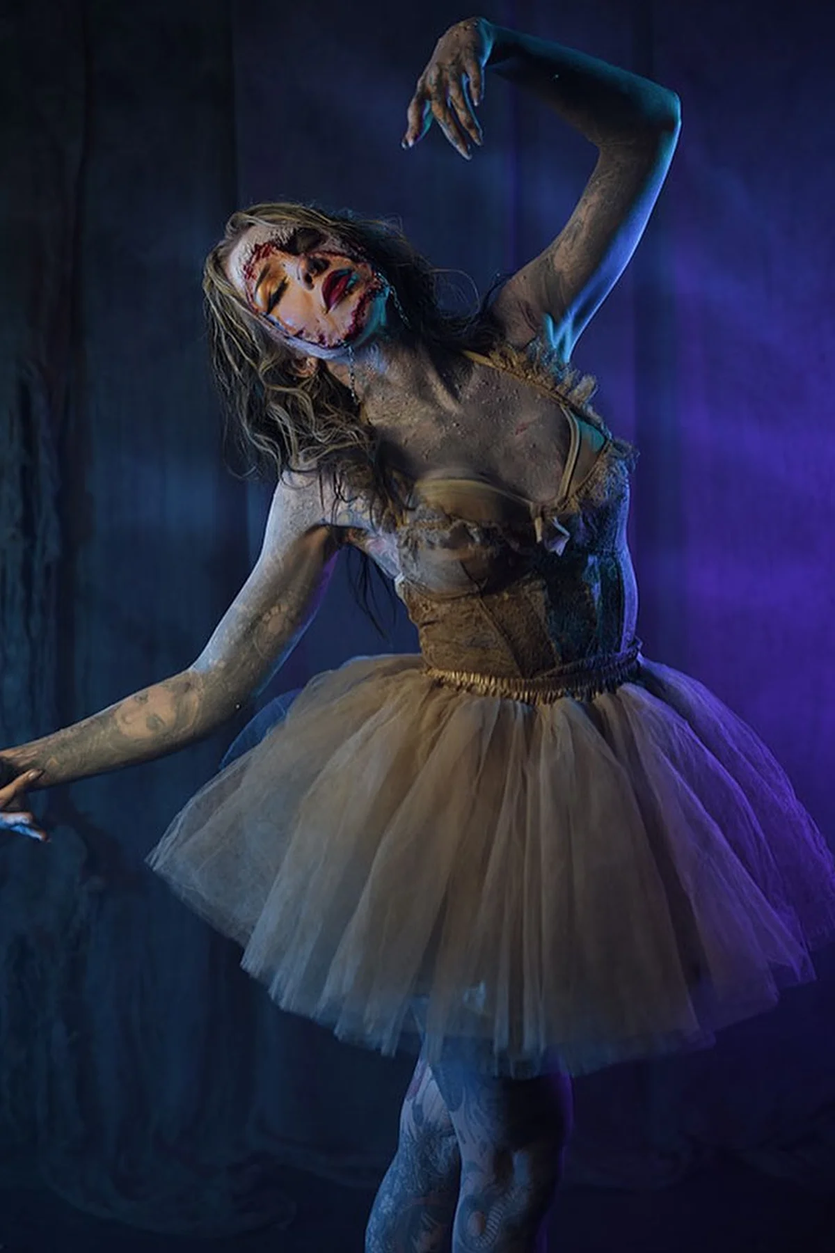 Woman in her 50s in a black leotard with a torn gray tutu in a dance pose, a haunted ballerina solo horror Halloween costume