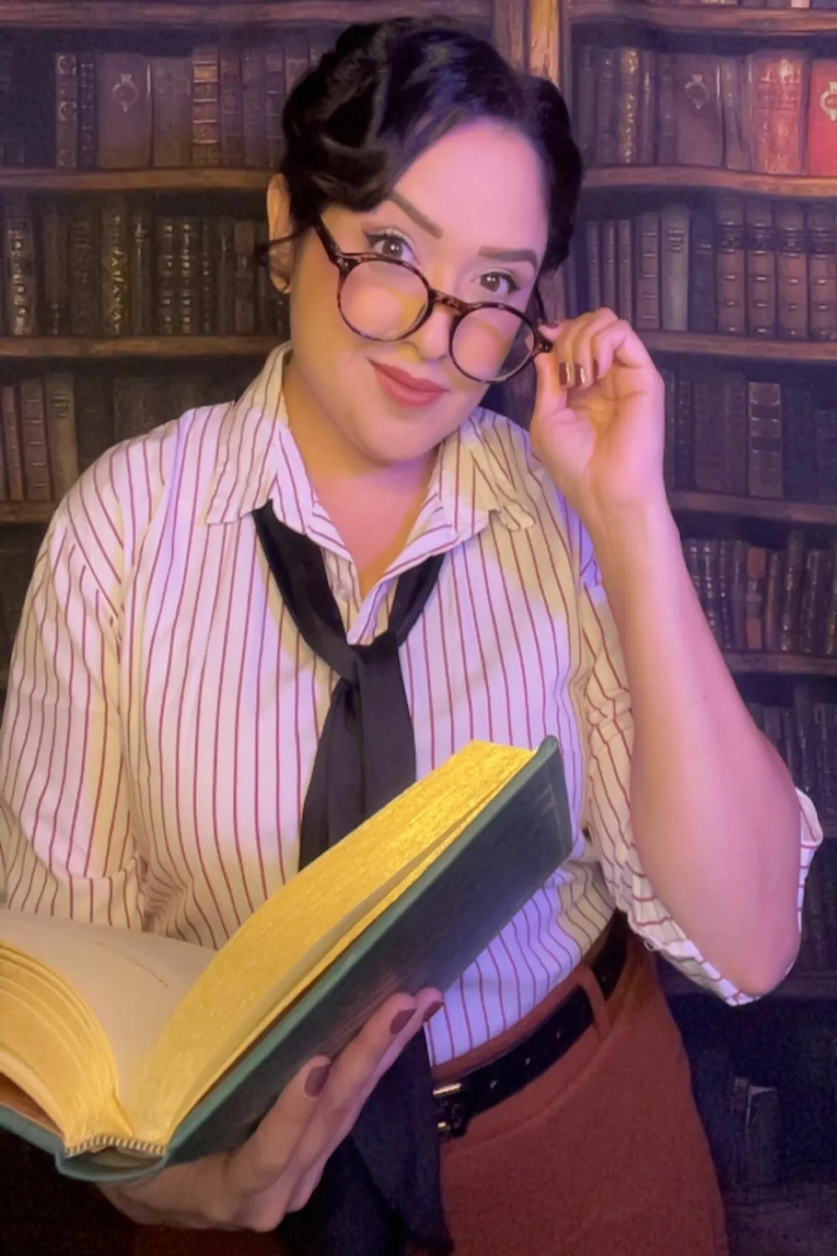 Woman in her 50s in a gray cardigan and glasses carrying old dusty books, a haunted librarian solo horror Halloween costume