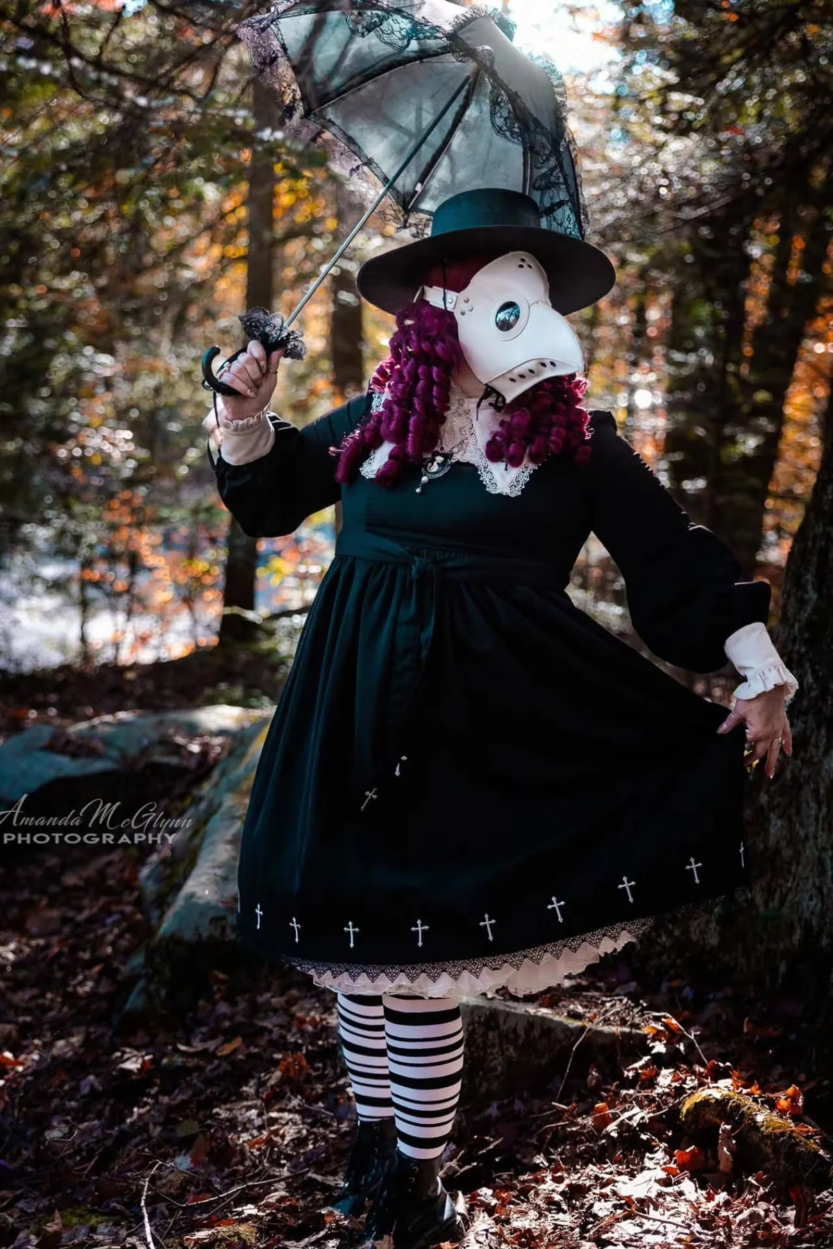Woman in her 50s in a black dress and white beaked plague doctor mask with a wide-brimmed hat holding a lace parasol, a gothic plague doctor solo horror Halloween costume