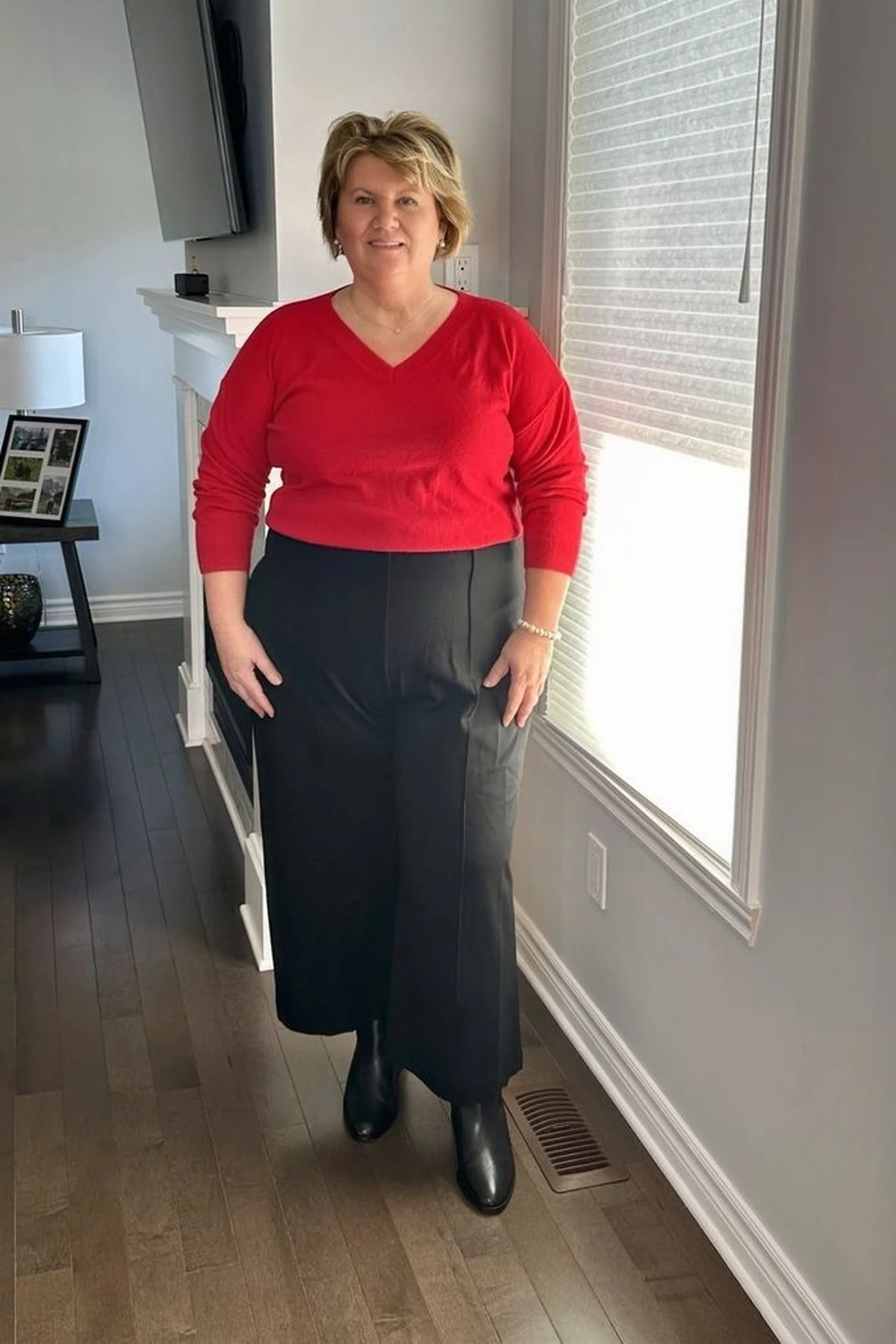 Woman in red cashmere sweater and black wide-leg pants at Christmas