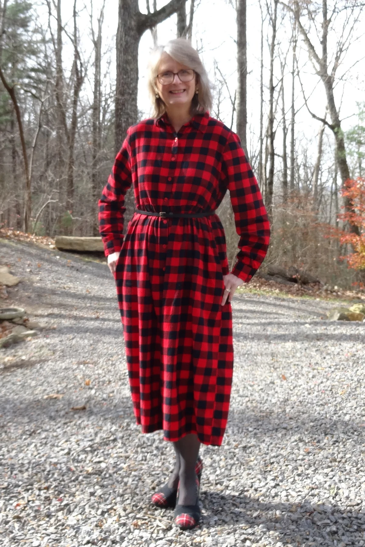 Woman in red buffalo-plaid shirt dress with a belt at Christmas