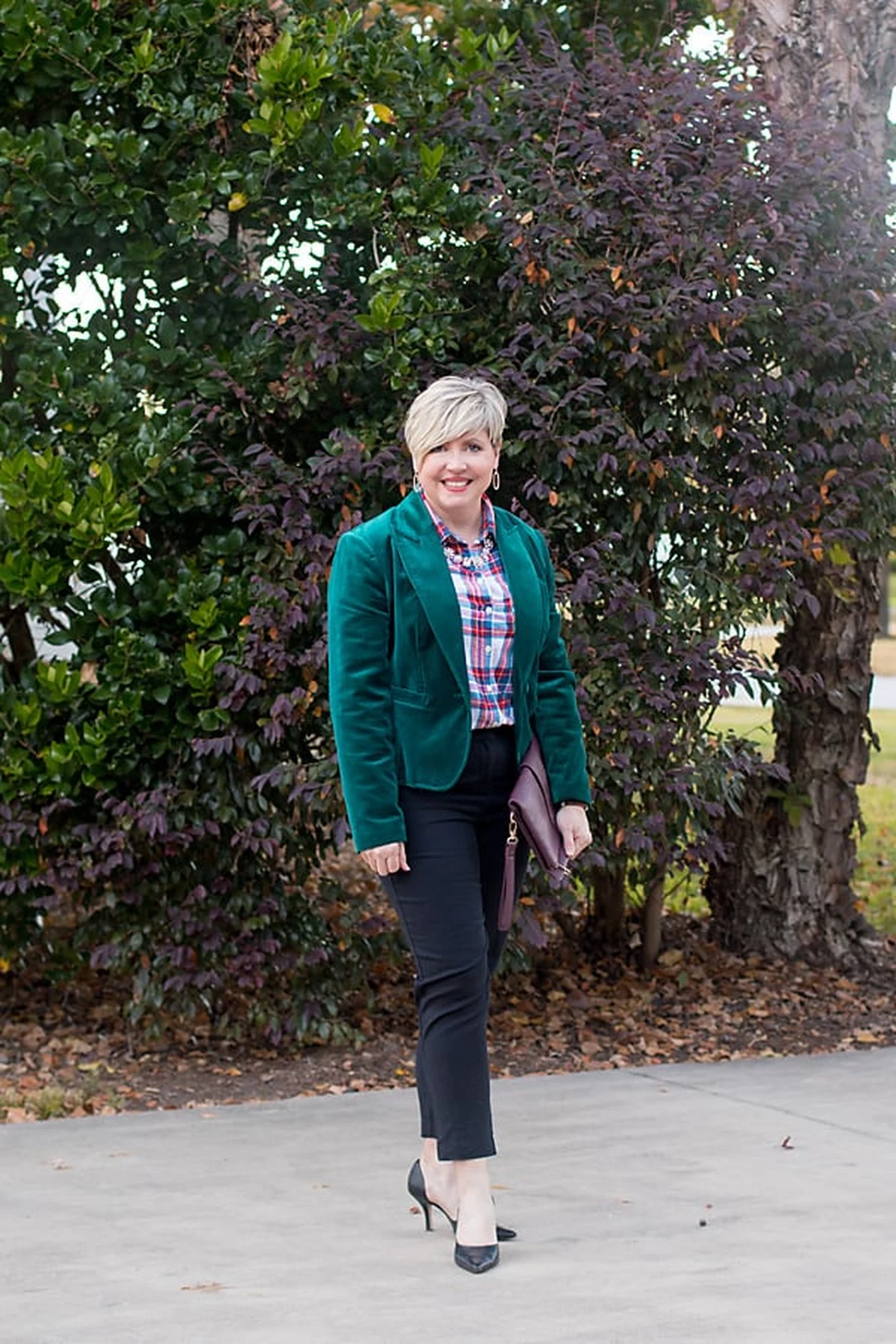 Woman in emerald velvet blazer and red plaid shirt at Christmas