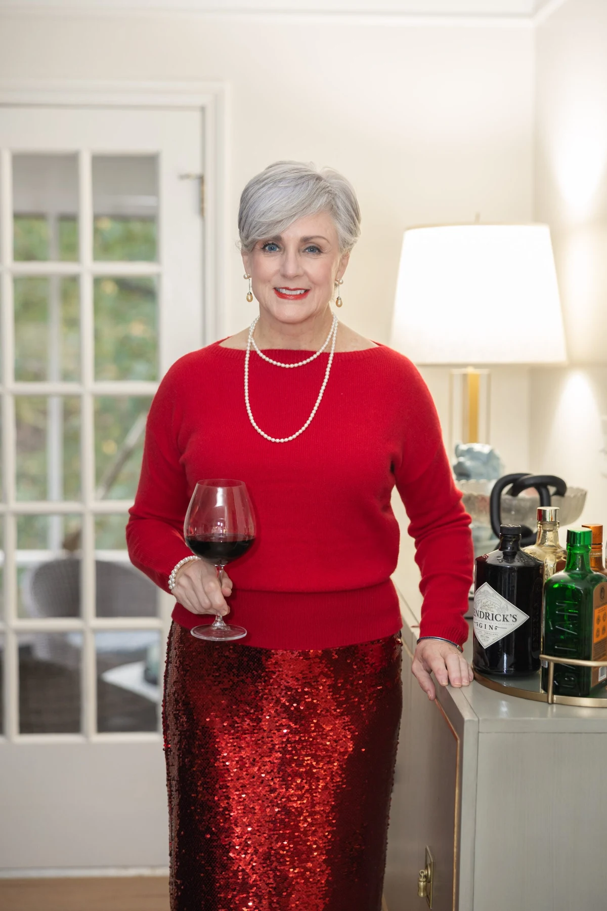 Woman in red boat-neck sweater and red sequin skirt at Christmas