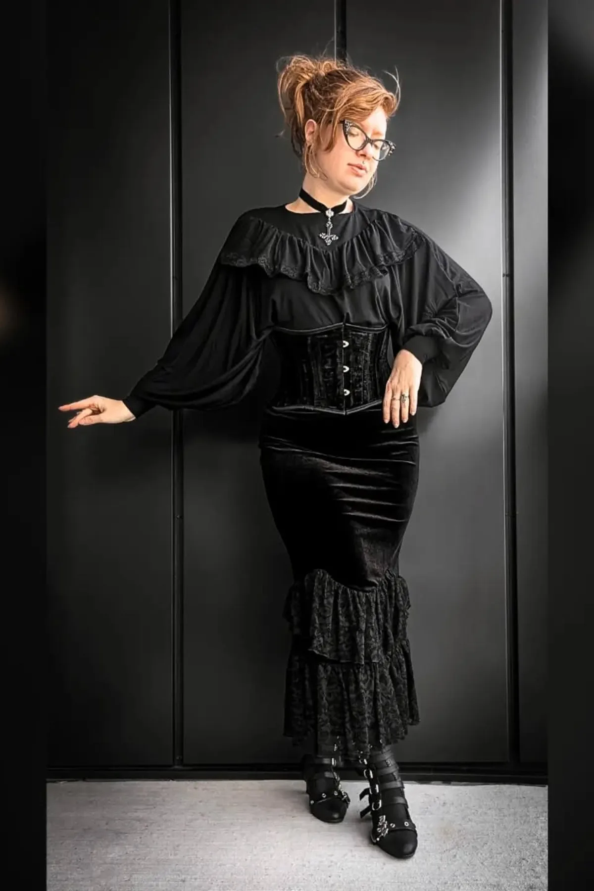 Woman in a black maxi skirt and cream ruffle blouse, a Victorian gothic Halloween costume