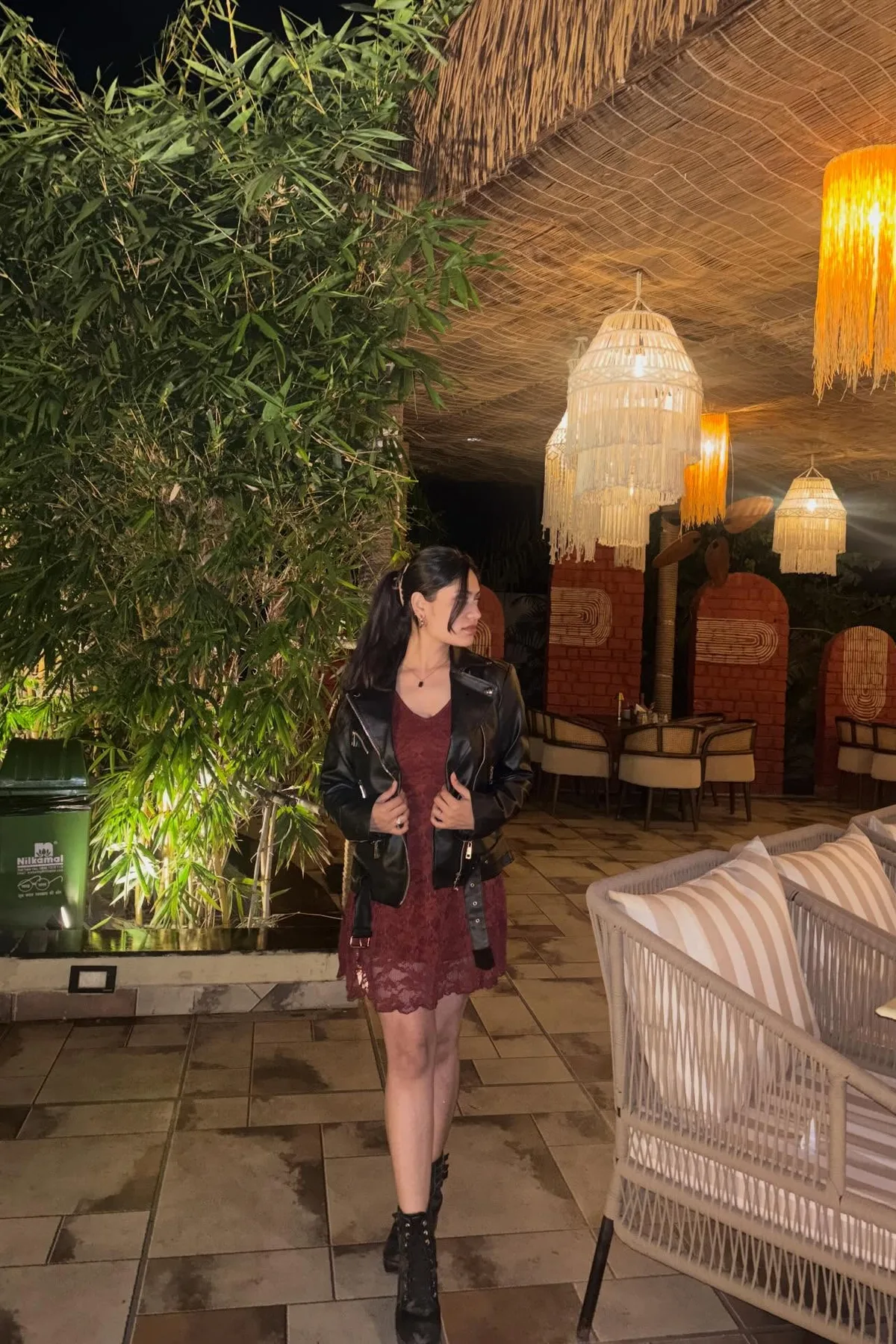 Woman in a faux leather jacket and burgundy dress, a stylish gothic Halloween costume