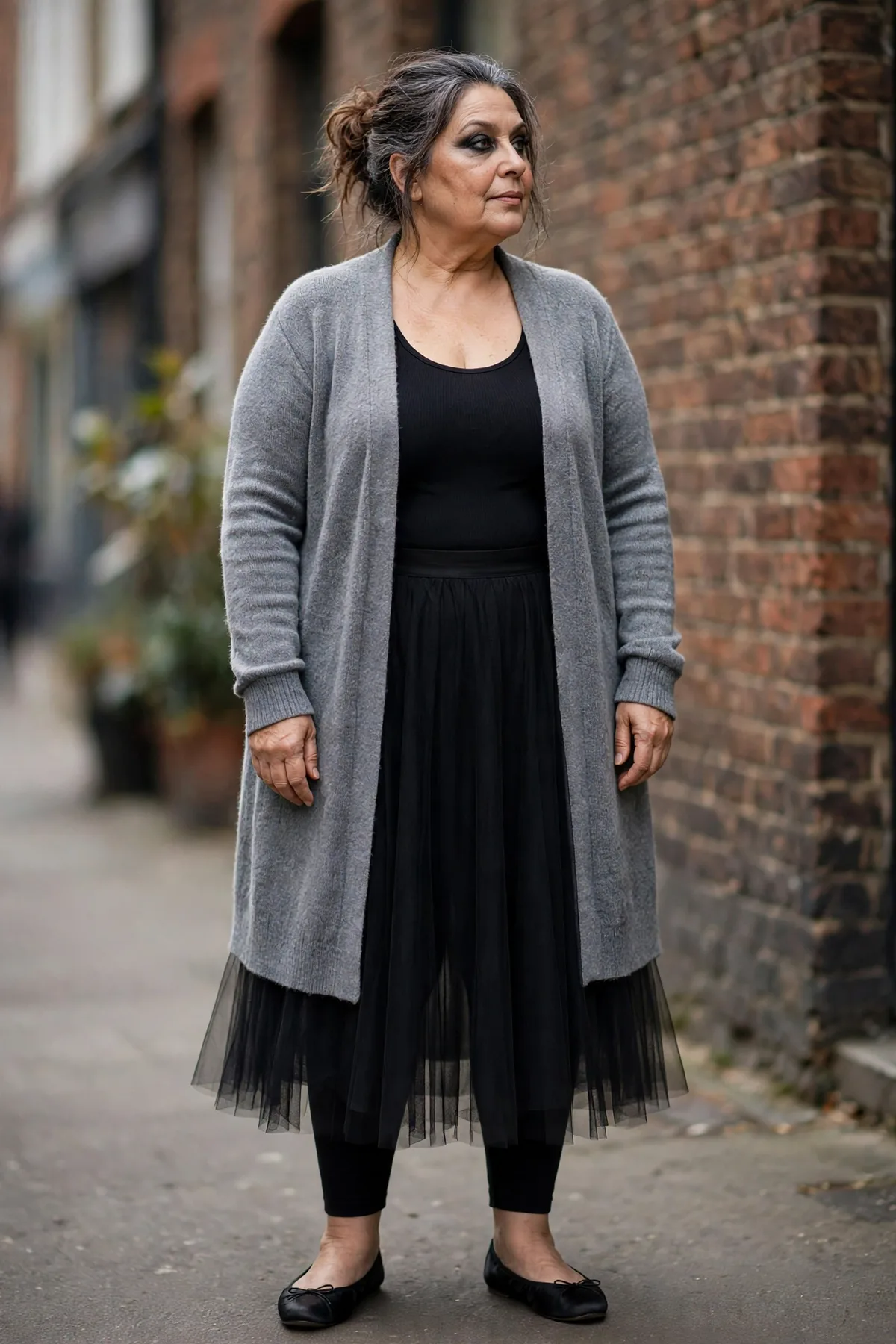 Woman in a black tulle skirt and gray cardigan, a ghoul ballerina Halloween costume