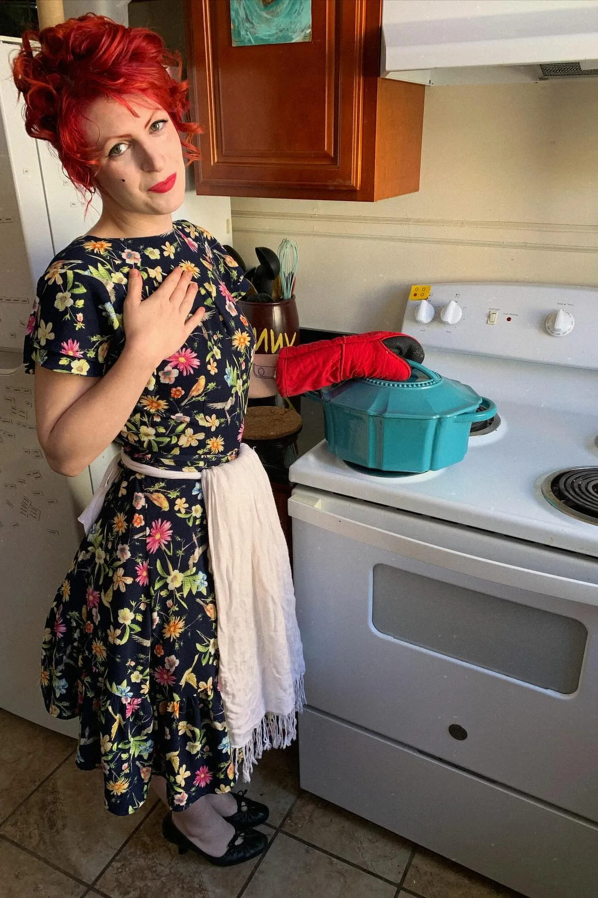 Woman in a floral shirtdress and apron, a retro horror housewife Halloween costume