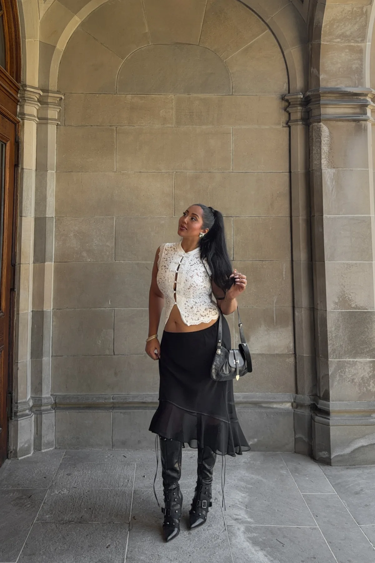 Woman in a cream lace blouse and faux leather skirt, a romantic gothic Halloween costume