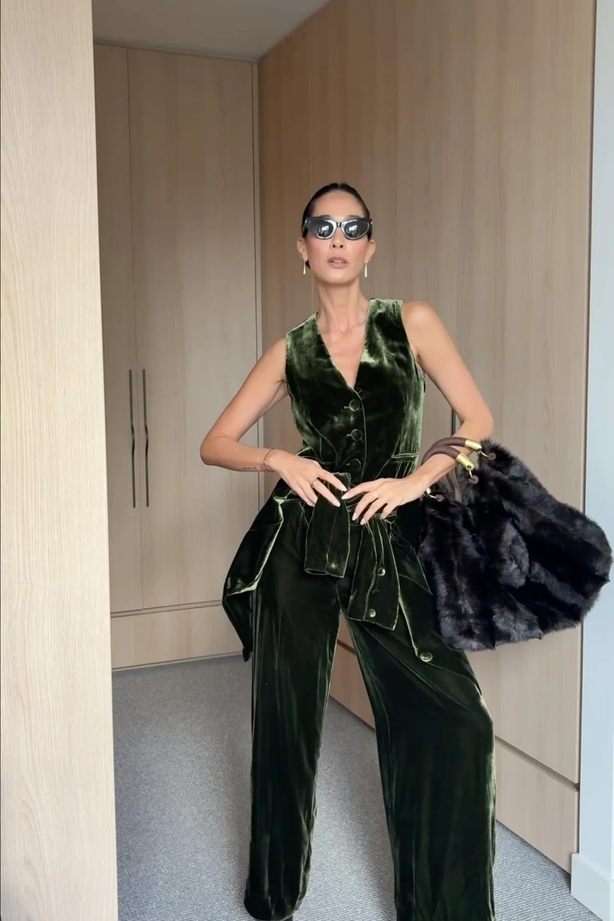Woman in an emerald velvet wrap top and black trousers, a chic gothic Halloween costume